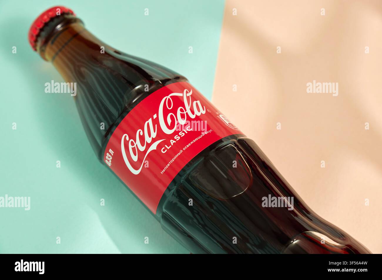 Tyumen, Russia-20 aprile 2026: Fotografia dello stile di vita moderno: bottiglia di Coca-Cola e motivi di ombra lineari Foto Stock