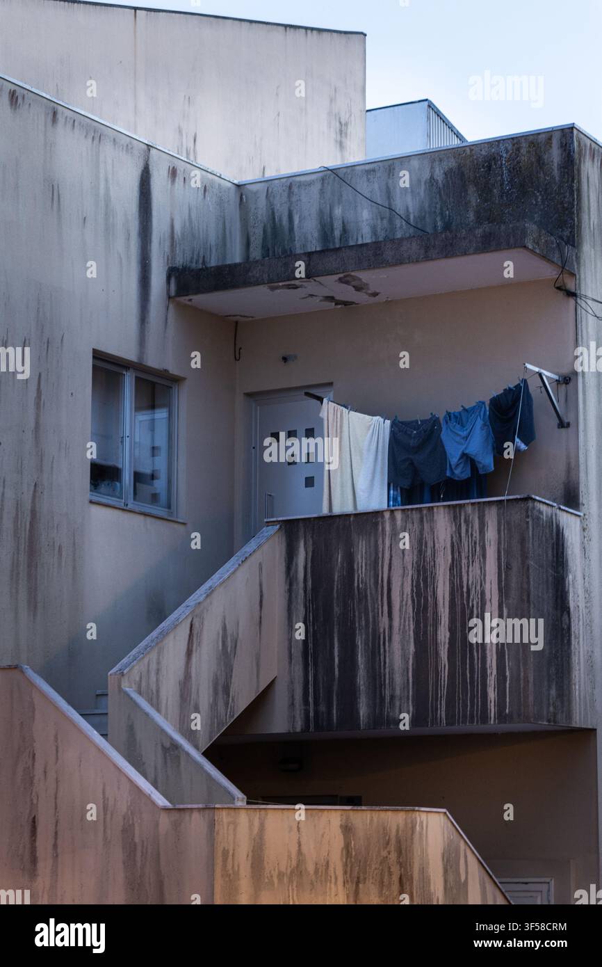 Vestiti che si asciugano su un balcone stagionato dalle intemperie Foto Stock