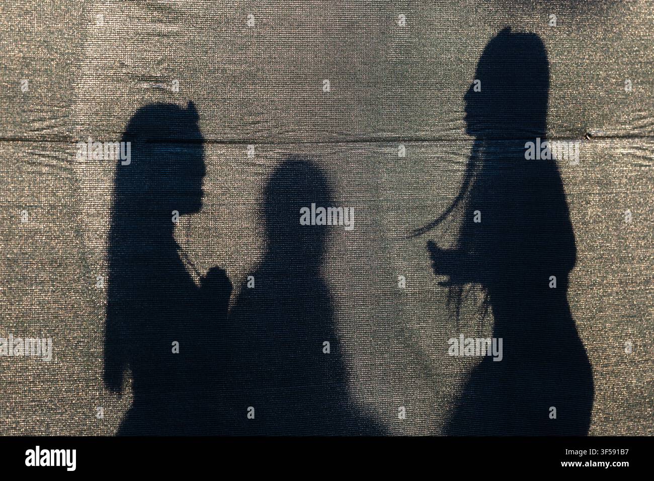 Tre ombre di pedoni formano silhouette su un muro a Boston, Massachusetts. Foto Stock