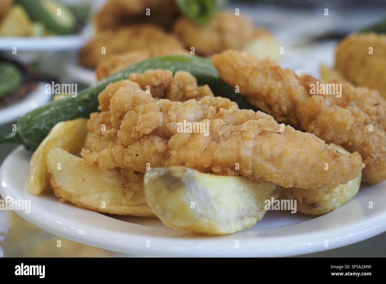 Delizioso pollo fritto con contorni su un piatto bianco Foto Stock