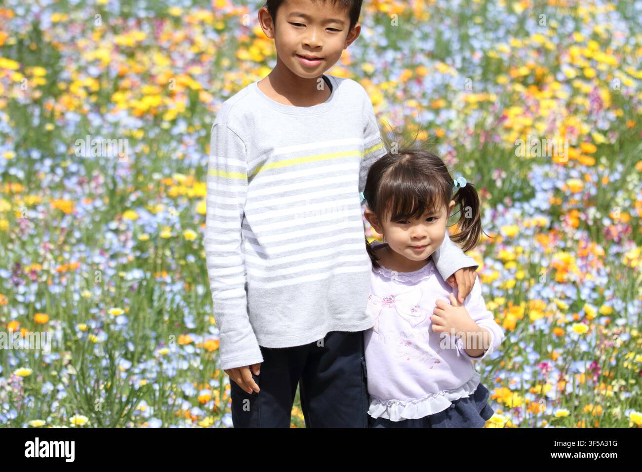 Fratello e sorella giapponesi e giardino di fiori (ragazzo di 8 anni e bambina di 3 anni) Foto Stock