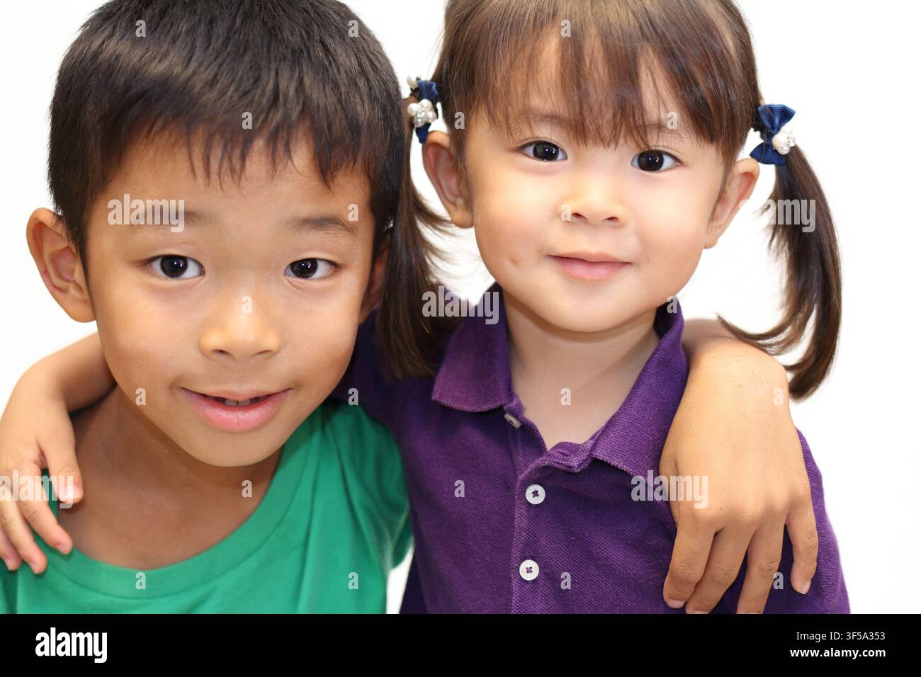 Fratello e sorella giapponesi che si mettono le braccia sulle spalle a vicenda (ragazzo di 8 anni e bambina di 3 anni) Foto Stock