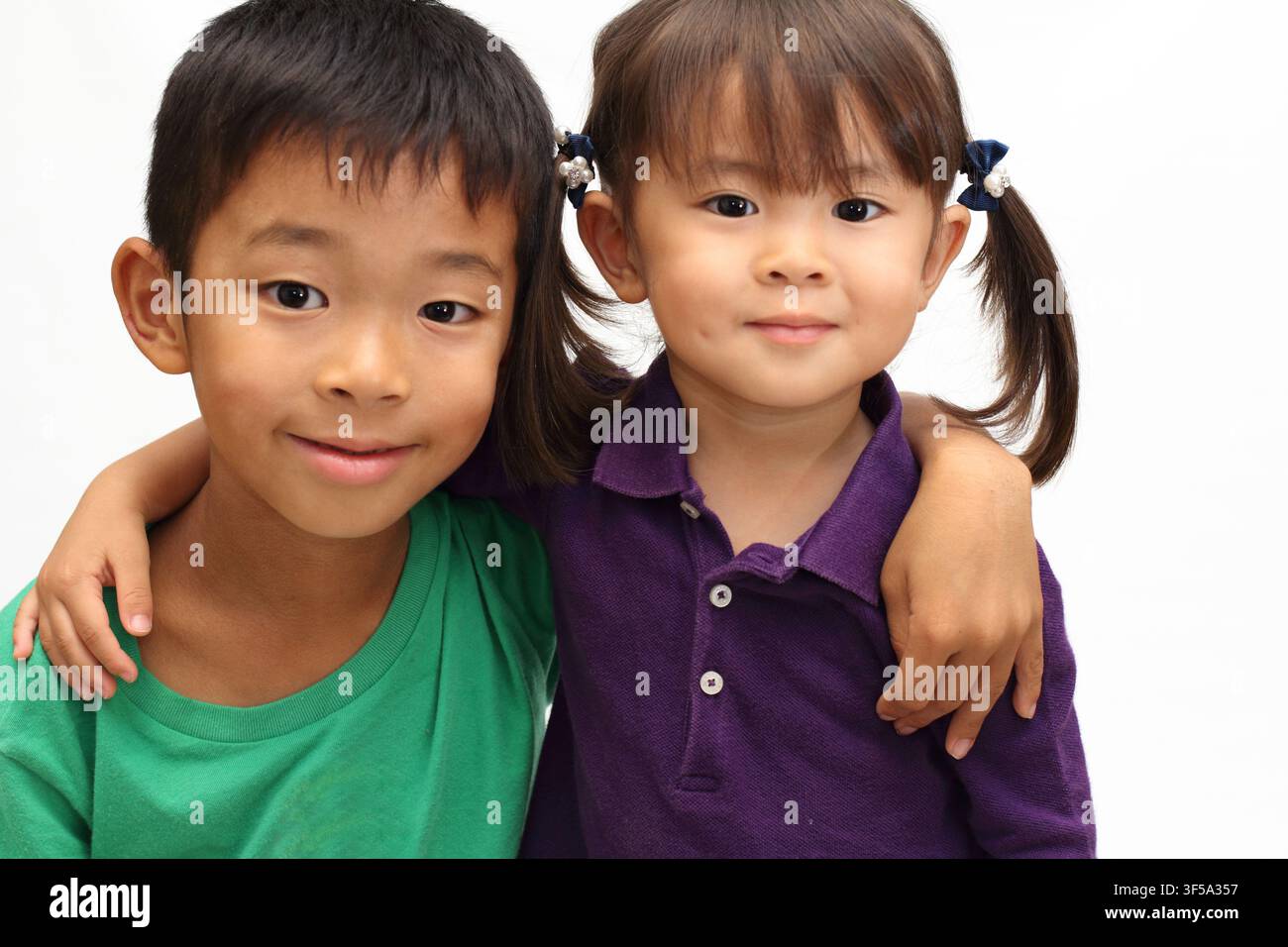 Fratello e sorella giapponesi che si mettono le braccia sulle spalle a vicenda (ragazzo di 8 anni e bambina di 3 anni) Foto Stock