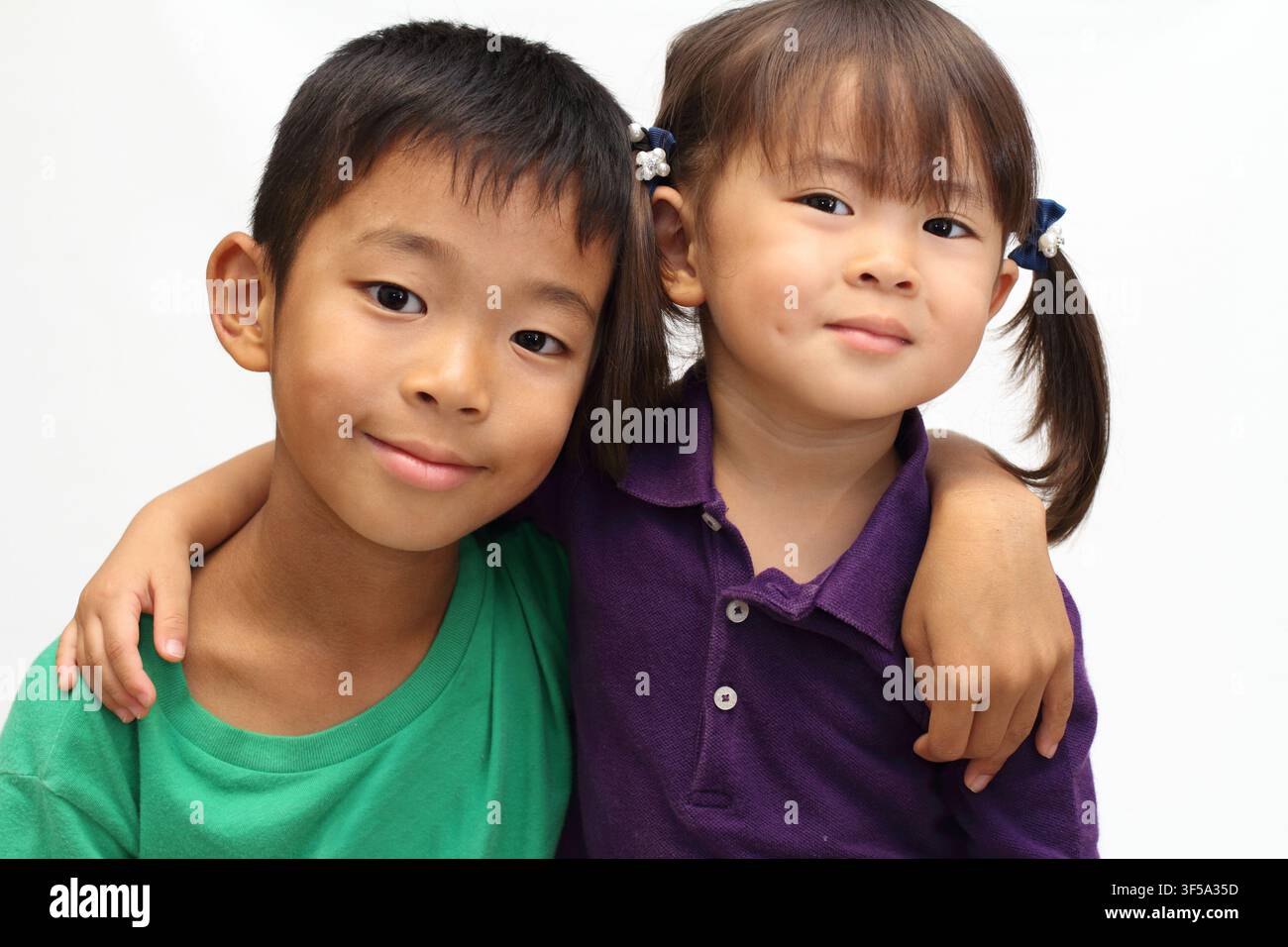 Fratello e sorella giapponesi che si mettono le braccia sulle spalle a vicenda (ragazzo di 8 anni e bambina di 3 anni) Foto Stock