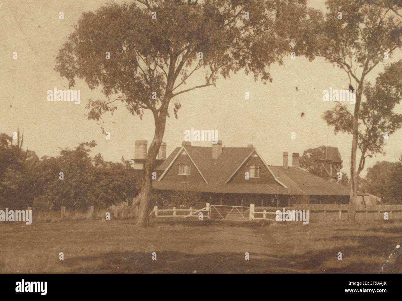 Fotografia d’archivio del paesaggio che mostra la vasta vista frontale, il cancello rustico in legno e i caratteristici timpani del tetto di Milong Homestead intorno al 1912. Foto Stock