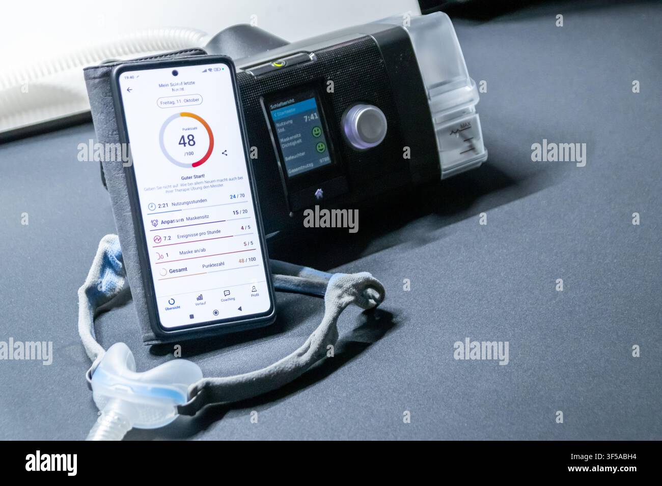 Macchina CPAP con maschera nasale CPAP e smartphone con app digitale per statistiche di trattamento e rapporti medici o rapporti sanitari e app assistente digitale Foto Stock