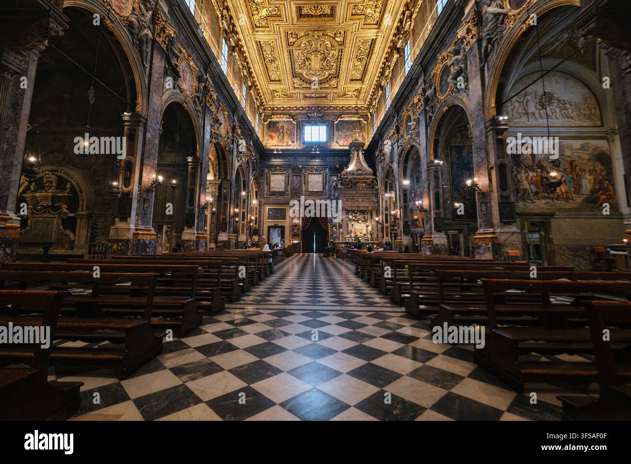 Firenze, Italia - Maggio 2026: Vista interna simmetrica della navata e del soffitto dorato all'interno della Basilica della Santissima Annunziata Foto Stock