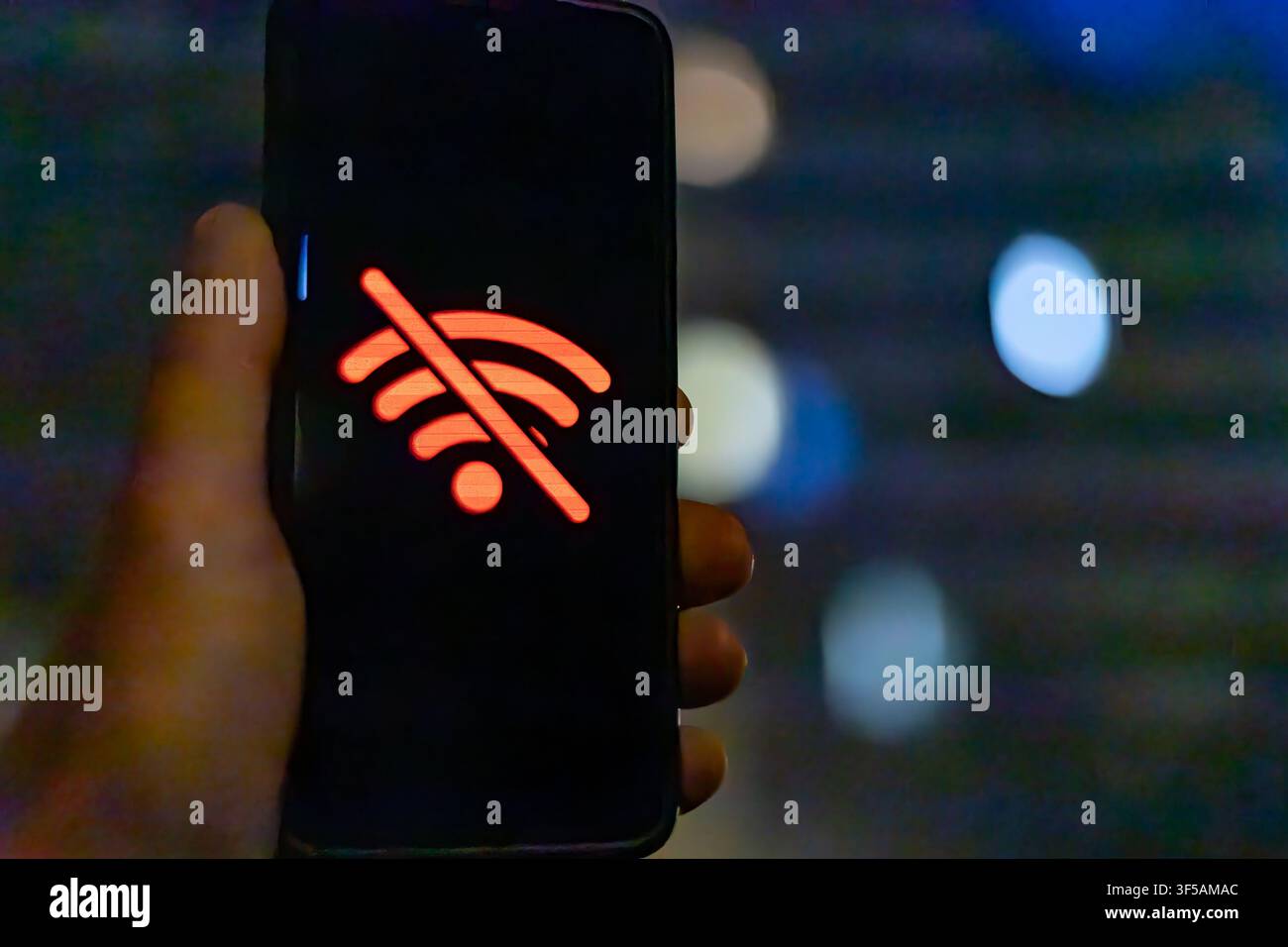 Icona di assenza di connessione Wi-Fi visualizzata sullo schermo dello smartphone di notte Foto Stock