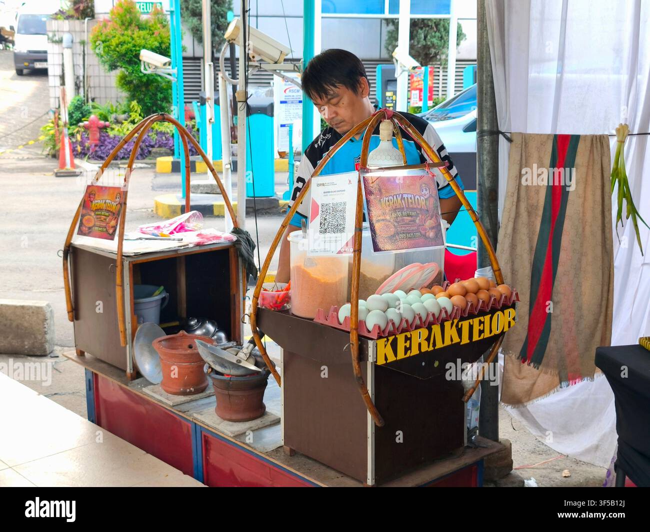 Un chiosco alimentare tradizionale Kerak Telor a Jakarta, dove un venditore locale prepara la delizia iconica Betawi utilizzando uova fresche e riso glutinoso Foto Stock