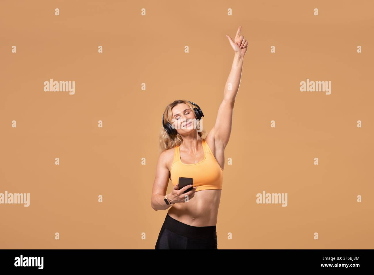 Vitalità, energia e stile di vita sano. Donna muta sorridente di mezza età con occhi chiusi in uniforme sportiva Foto Stock