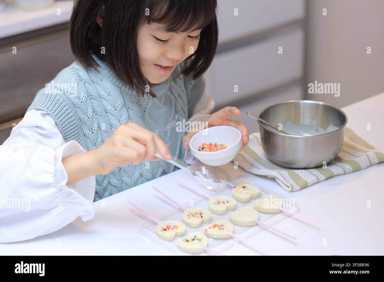 Studentessa giapponese che cucina cioccolato bianco (8 anni) Foto Stock