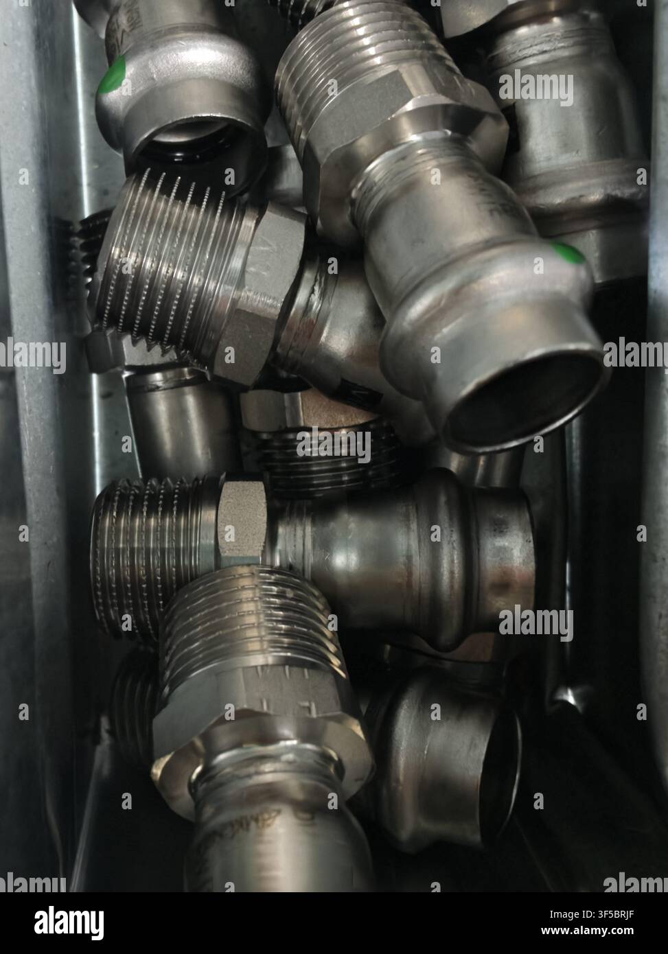 Raccordi idraulici metallici collegati e assemblati, in ambiente industriale o meccanico, con connettori per tubi metallici, raccordi filettati, da un Foto Stock