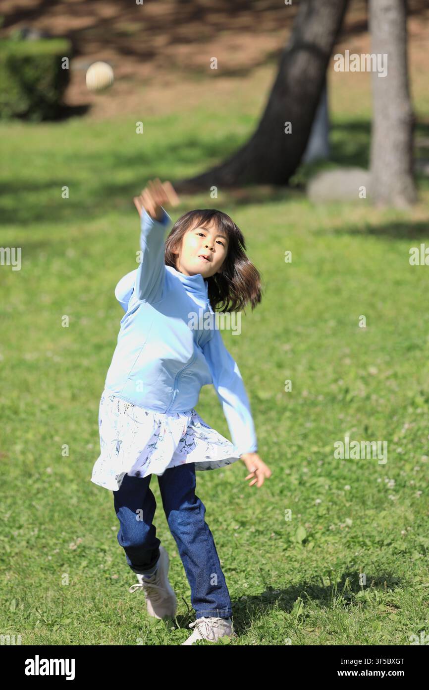 Studentessa giapponese che lancia una palla (8 anni) Foto Stock