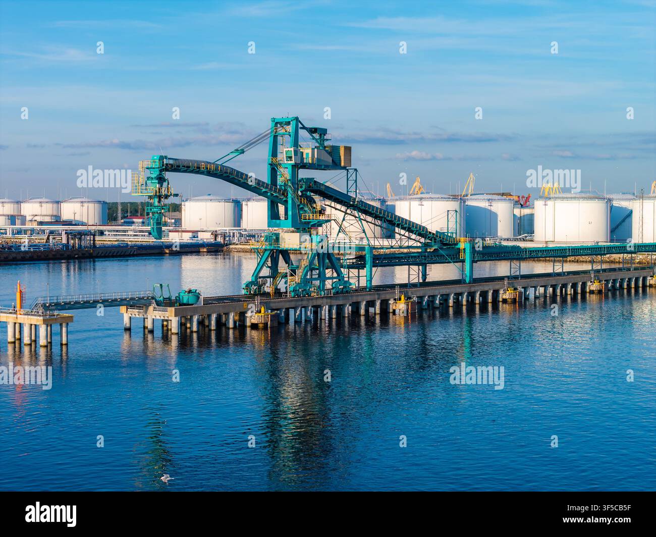 Vista aerea del terminal petrolifero di Ventspils con nastro trasportatore verde acqua e gru Foto Stock