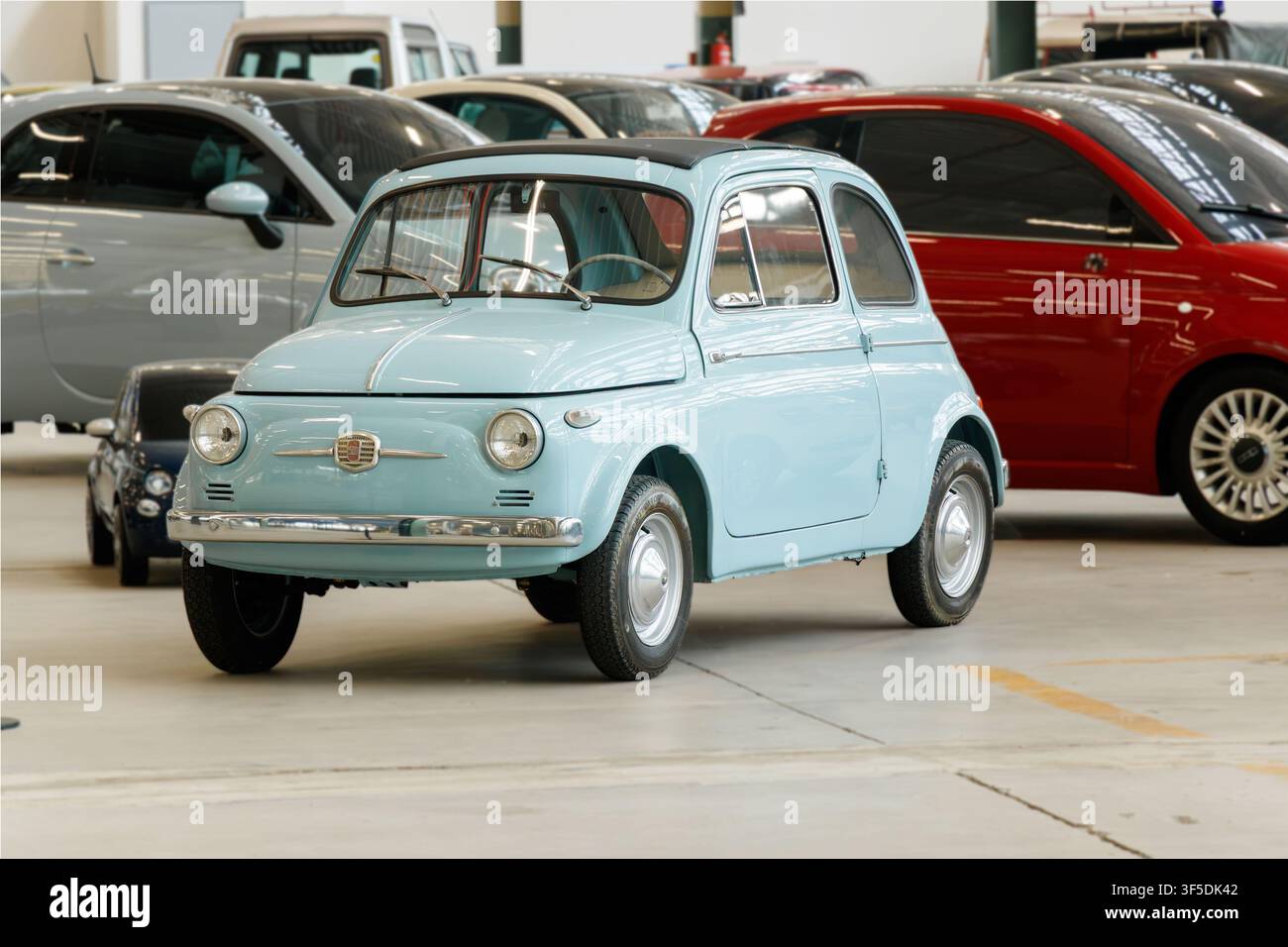 Veicolo classico Fiat 500 azzurro esposto in uno spazio espositivo e showroom Foto Stock