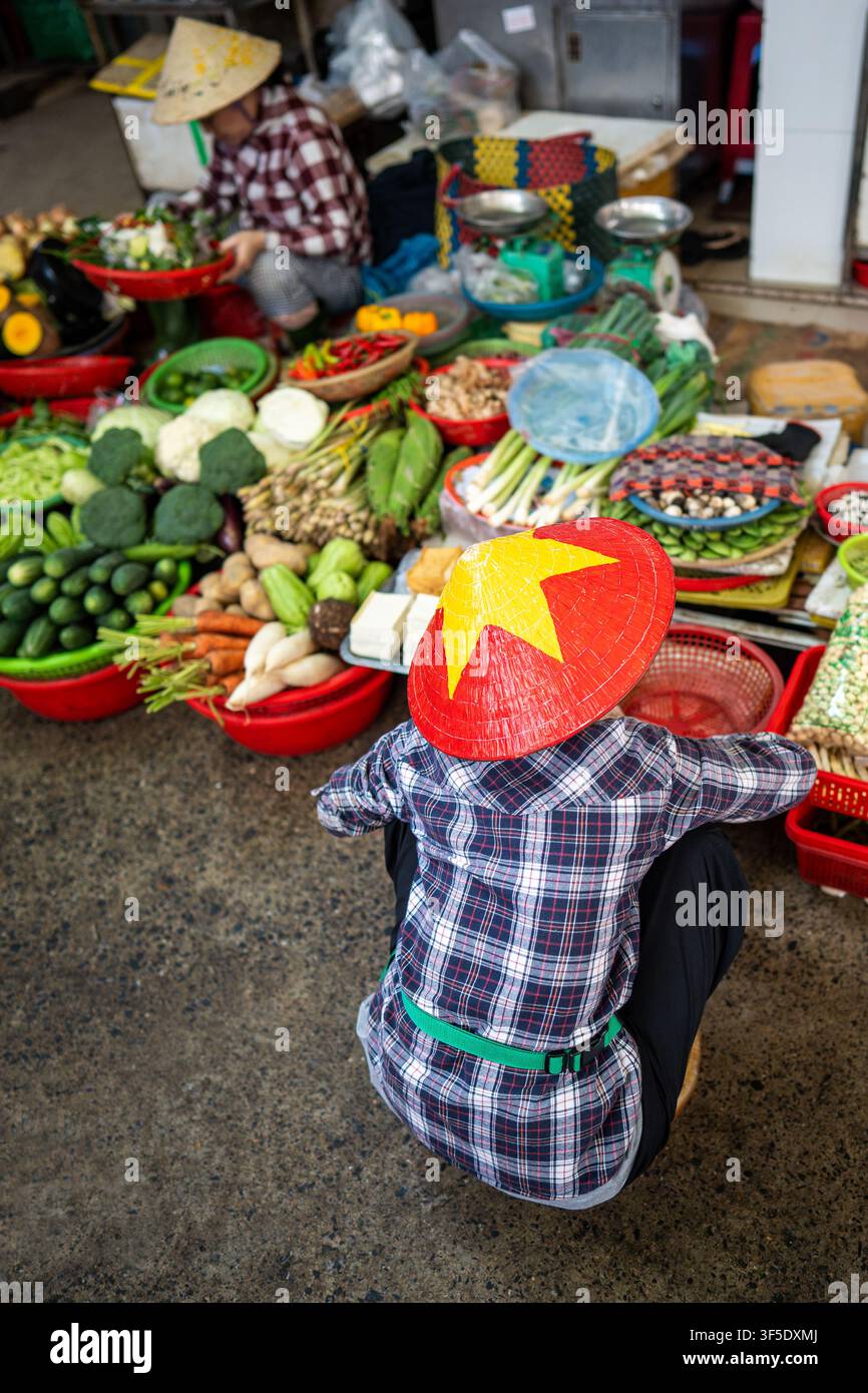 Venditori di mercato locale irriconoscibili che vendono verdure fresche, spezie e piante sul marciapiede. Foto Stock