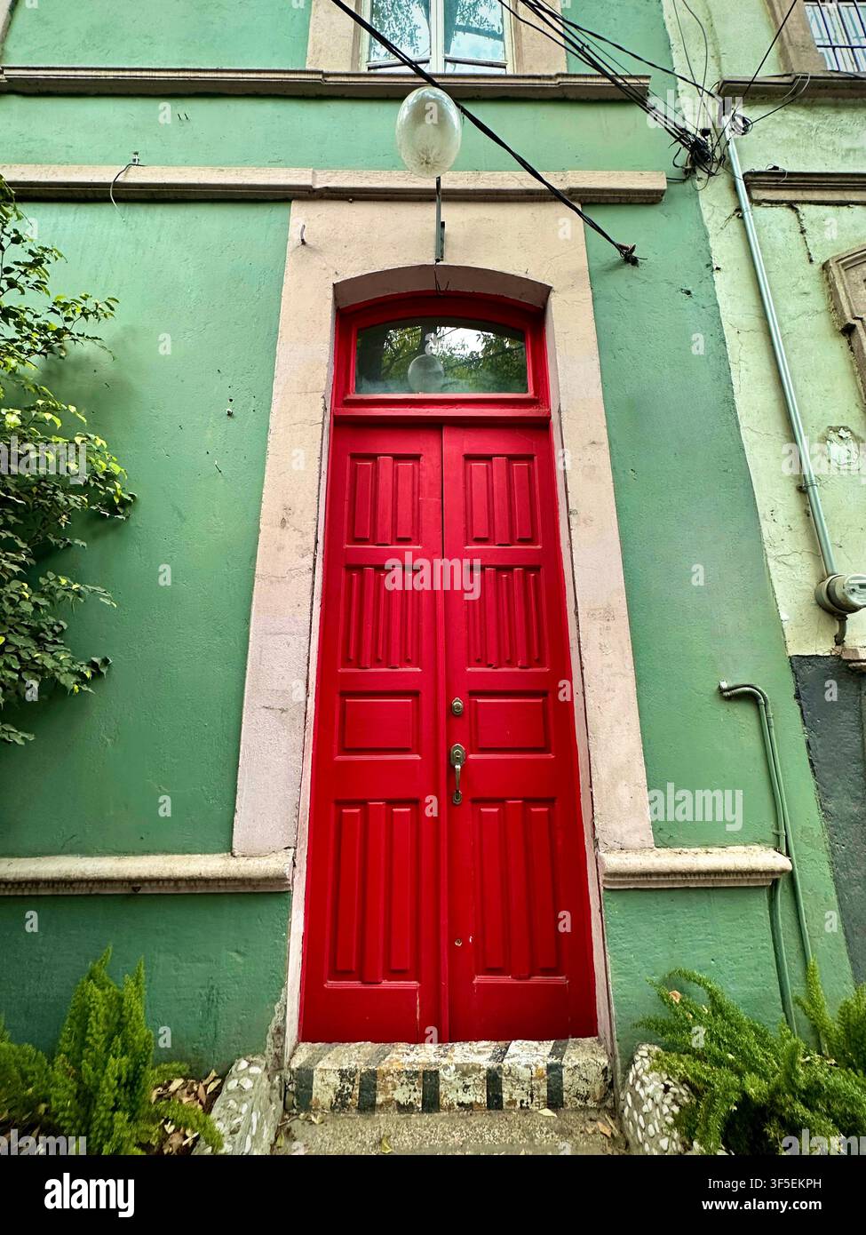 Casa verde con porta rossa audace (Città del Messico, Messico) Foto Stock