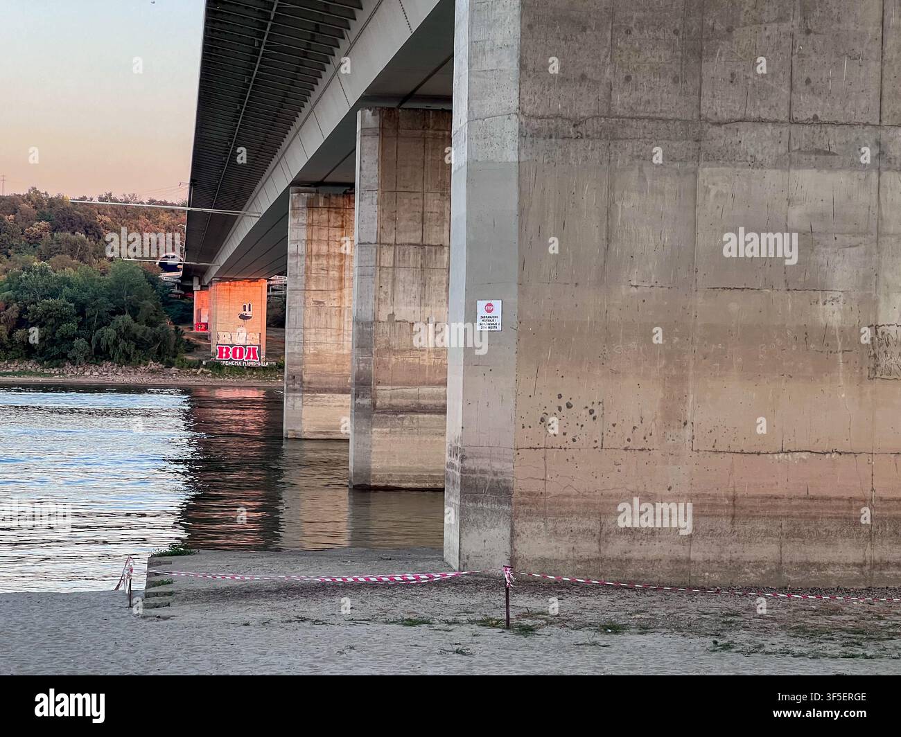 Livello dell'acqua storicamente basso del Danubio che espone i pilastri del ponte sotto il Ponte della Libertà a Novi Sad, Serbia, durante una siccità estrema. - Immagine stock catturata con smartphone