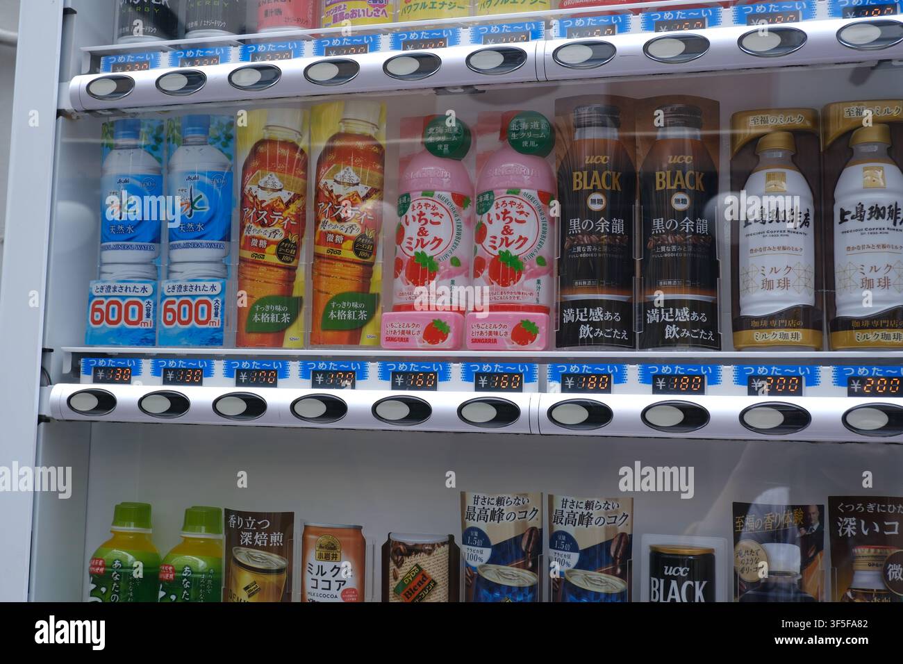 Una vista ravvicinata di un display di distributore automatico giapponese che mostra varie bevande fredde in bottiglia e lattina. Foto Stock
