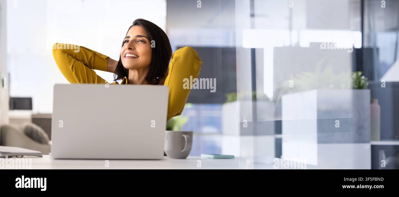 Dipendente d'ufficio spensierata che si rilassa alla scrivania del lavoro Foto Stock