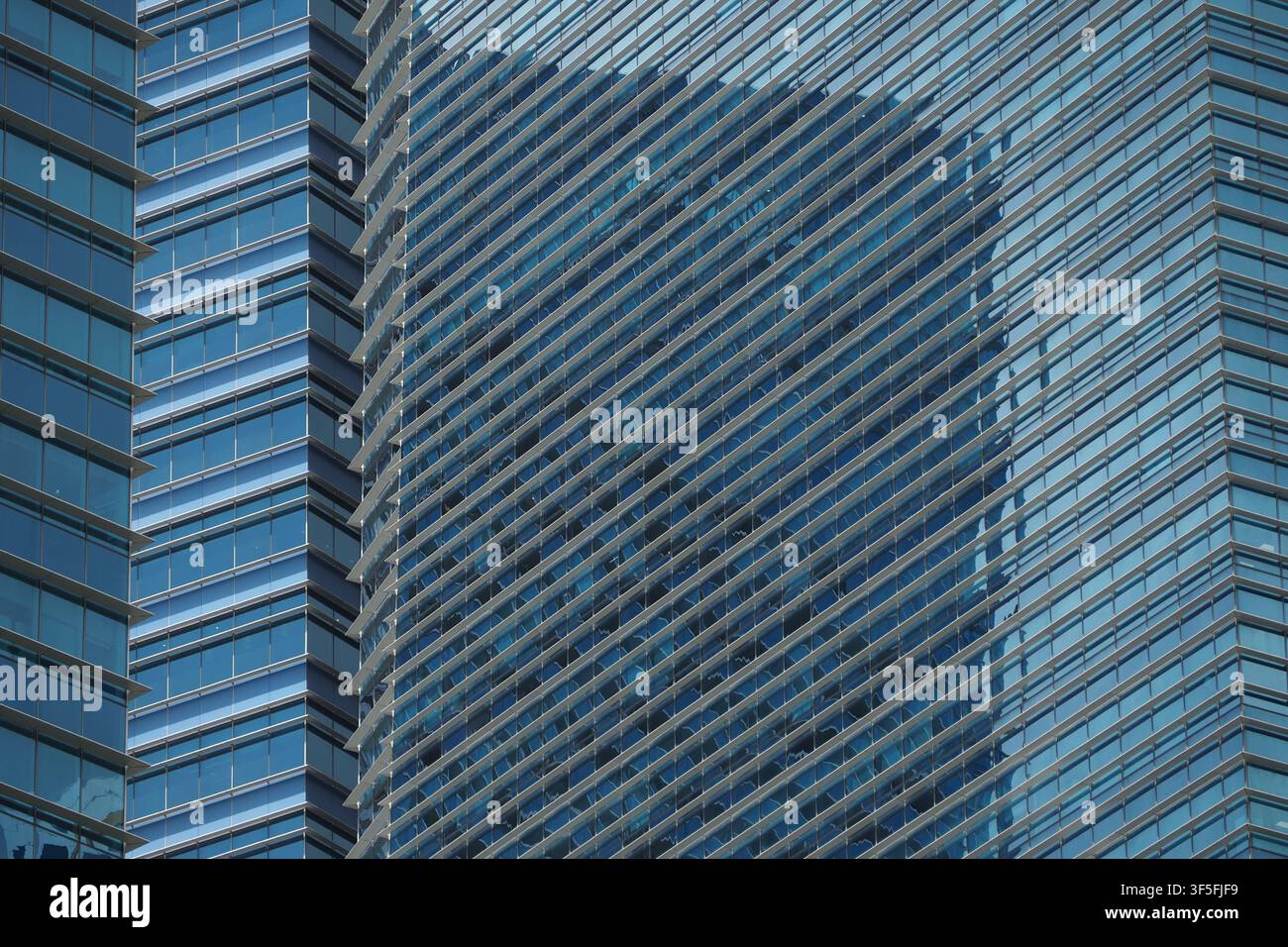 Gli edifici alti riflettono la luce e contrastano tra loro Foto Stock