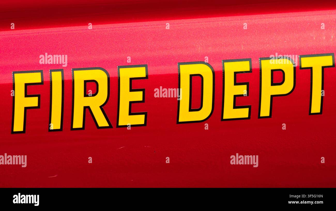 Primo piano delle lettere gialle audaci del Dipartimento dei Vigili del Fuoco su un veicolo di emergenza rosso utilizzato dai soccorritori della Contea di Los Angeles. Foto Stock