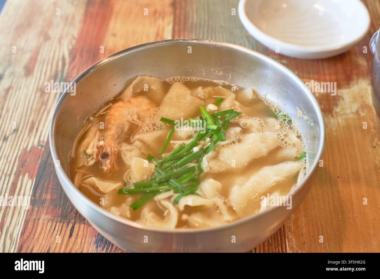 Sujebi, zuppa coreana con impasto strappato a mano con gamberetti e erba cipollina, un tradizionale comfort food comunemente servito nei ristoranti coreani informali. Foto Stock
