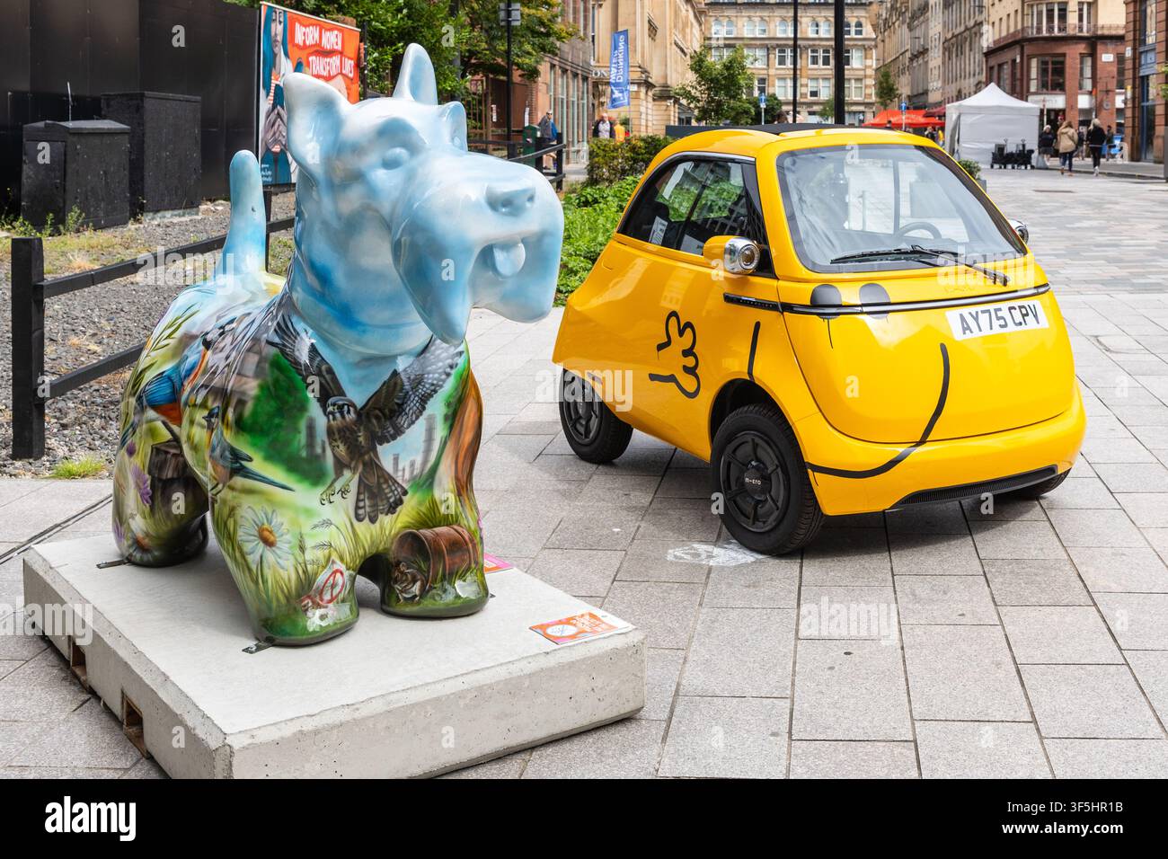 Arte di strada di un cane Scottie dipinto e di una piccola auto Isetta colorata di giallo in esposizione nel distretto di Merchant City, Glasgow, Scozia Foto Stock