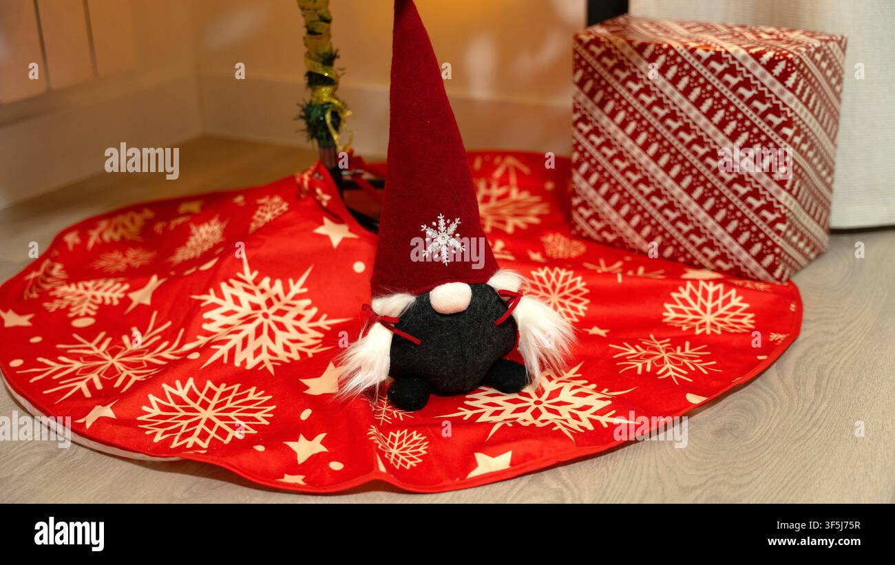 Gnomo di Natale che decora una gonna festosa per l'albero delle feste Foto Stock