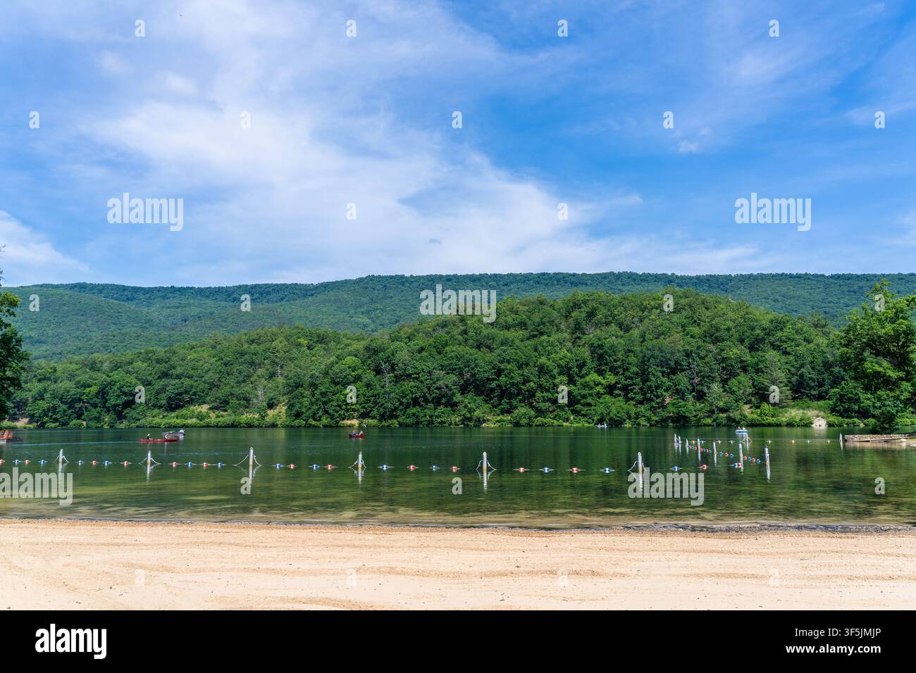 Douthat State Park – 8 giugno 2026: Spiaggia di sabbia sul lago Douthat con persone che navigano e fanno canoa in lontananza, Virginia Douthat State Park Foto Stock