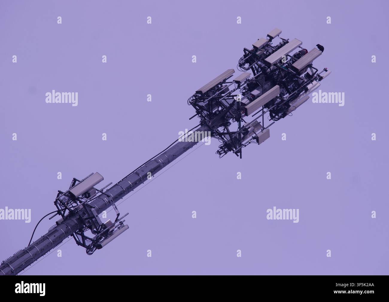 Prima piano ad angolazione bassa di una moderna torre di comunicazione cellulare con più antenne contro un cielo nuvoloso. Per concetti di 5G, telecomunicazioni Foto Stock