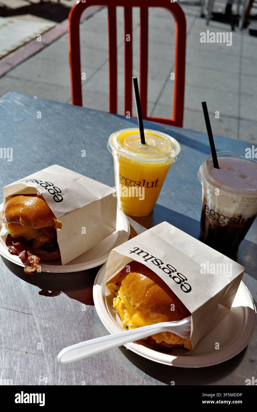 Sandwich per la colazione e bevande Eggslut su un tavolo all'aperto del caffè Foto Stock