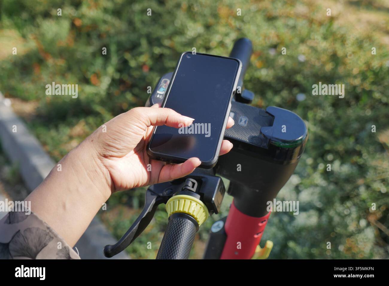 Utilizzare un telefono per scansionare il codice QR dello scooter elettrico Foto Stock