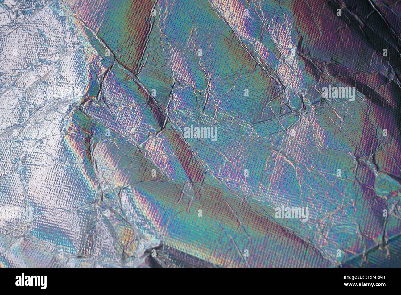 Primo piano di una lamina olografica rugosa con colori iridescenti arcobaleno e texture metallica. Ideale per design futuristico, astratto e creativo ba Foto Stock