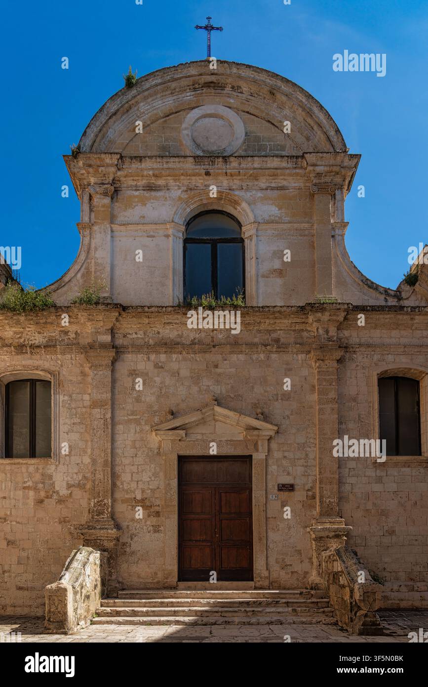 Facciata barocca in pietra della chiesa dei Santi Pietro e Paolo con frontone sormontato da una croce e scalinata. Monopoli, Provincia di Bari, Puglia, Italia, Europa Foto Stock