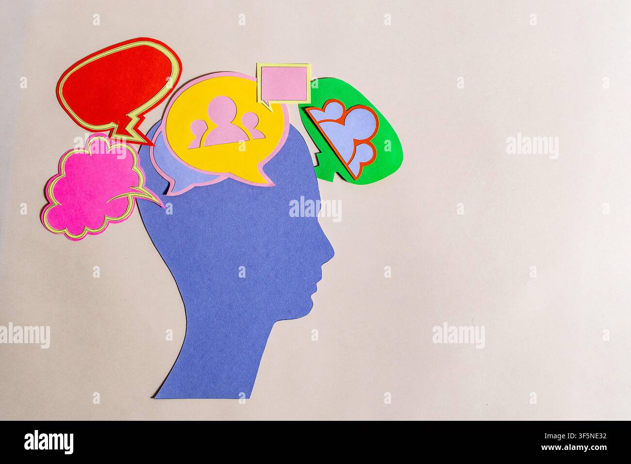 Arte del taglio di carta che mostra un profilo di testa blu con bolle di pensiero colorate che rappresentano pensieri sociali, comunicazione e salute mentale. Foto Stock