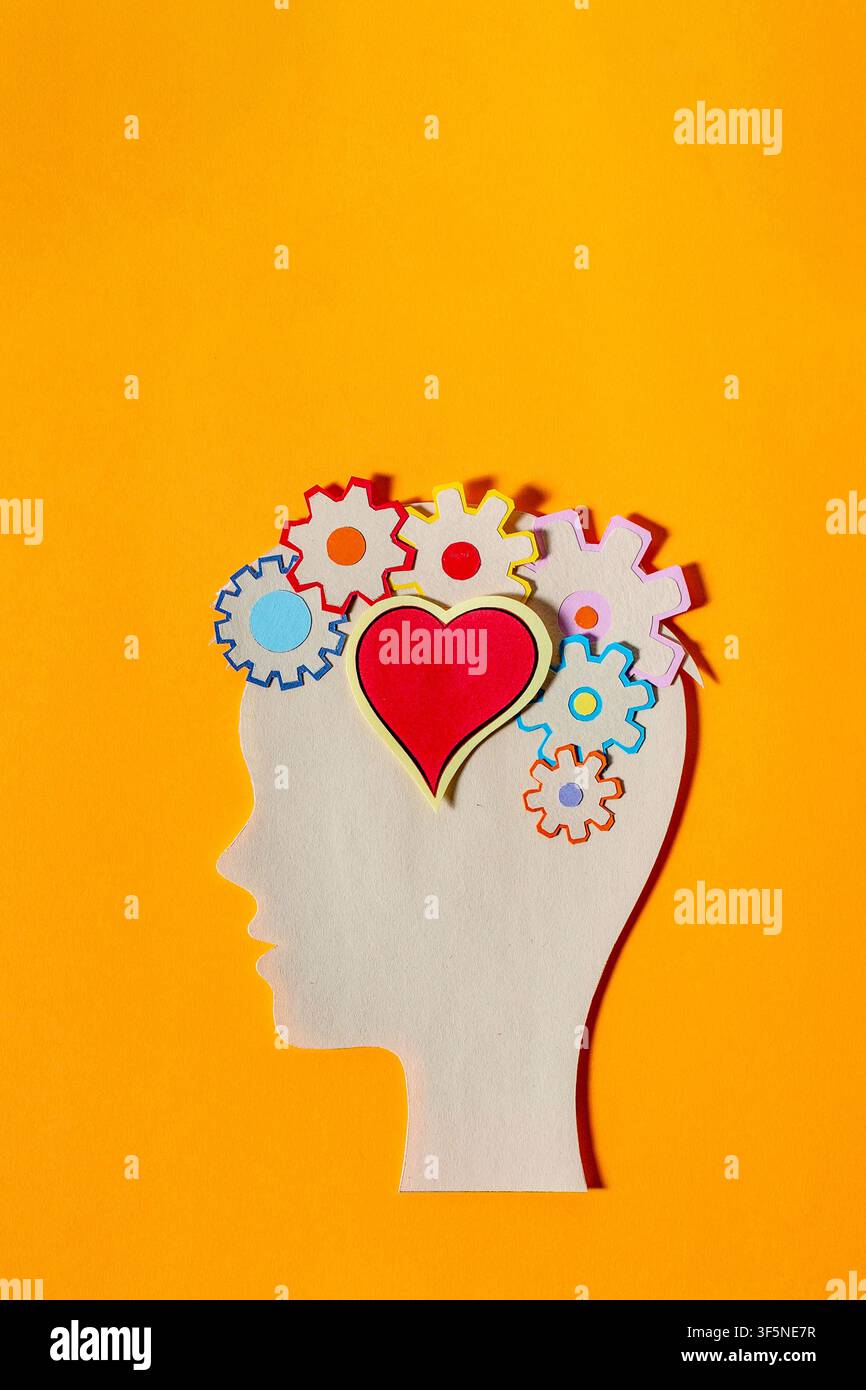 Illustrazione di taglio di carta che mostra una mente piena di ingranaggi e un cuore, simboleggiando il miscuglio di sentimenti e logica. Foto Stock