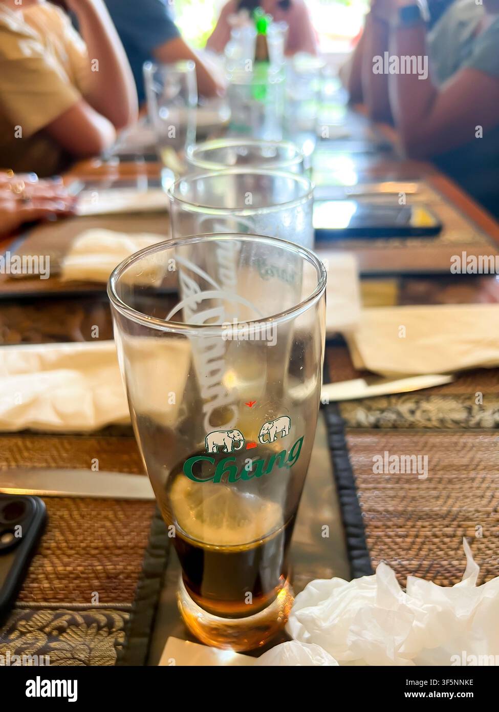 Una fila di bicchieri su un tavolo mentre si mangia un pasto con gli amici in un ristorante Foto Stock