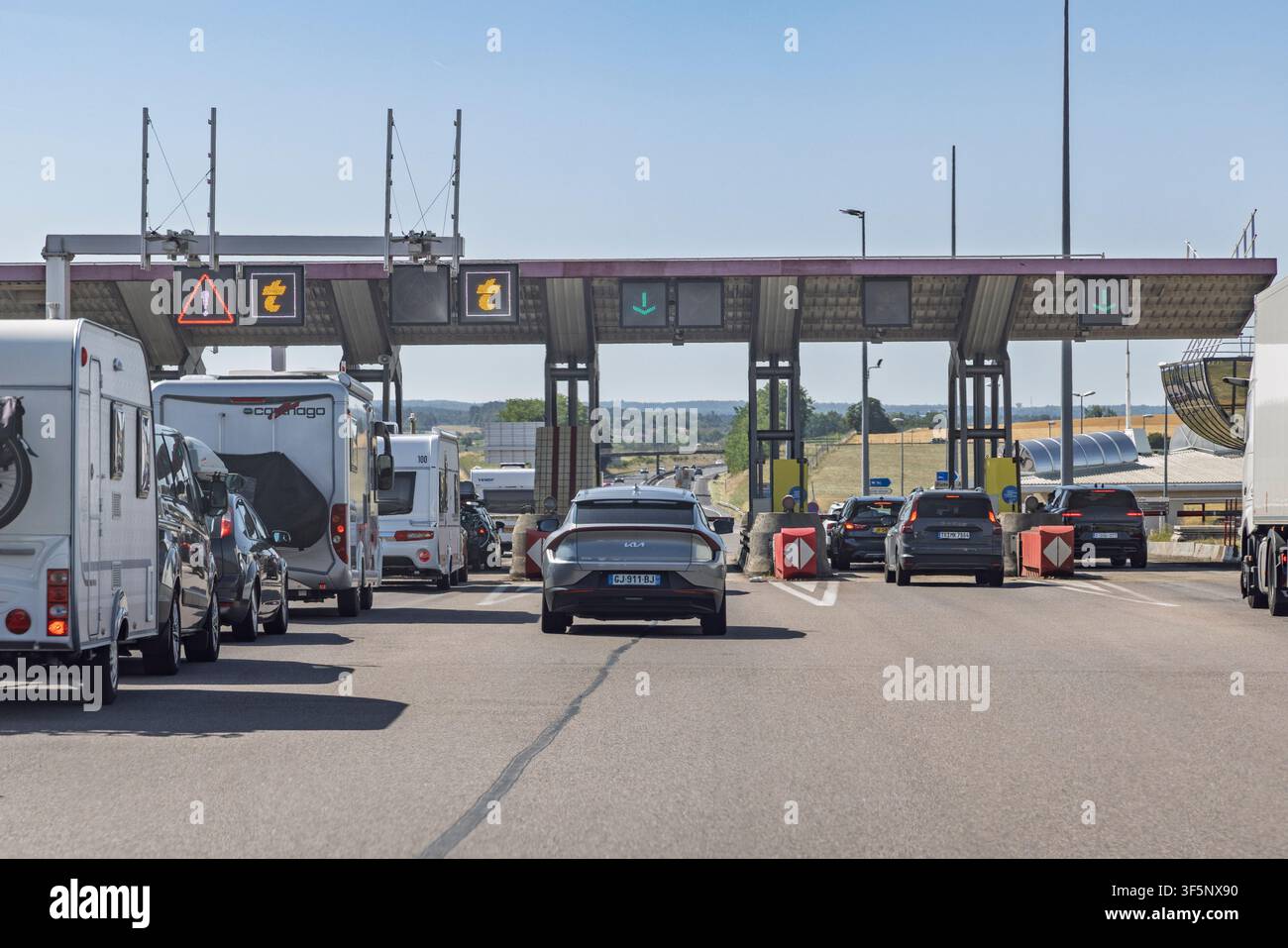 Francia - 24 luglio 2026: Primo piano dei cancelli del casello di pedaggio su un'autostrada francese che mostra segnali a freccia verde, cartelli di avvertimento e simboli Telepeage per il conducente Foto Stock