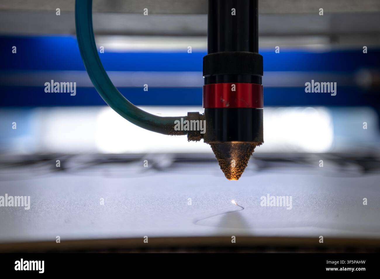 Macchina per il taglio laser che incide dettagli su una superficie piatta con uno strumento a lente ad alta precisione, attrezzatura per la produzione industriale che lavora nello spazio di lavoro Foto Stock