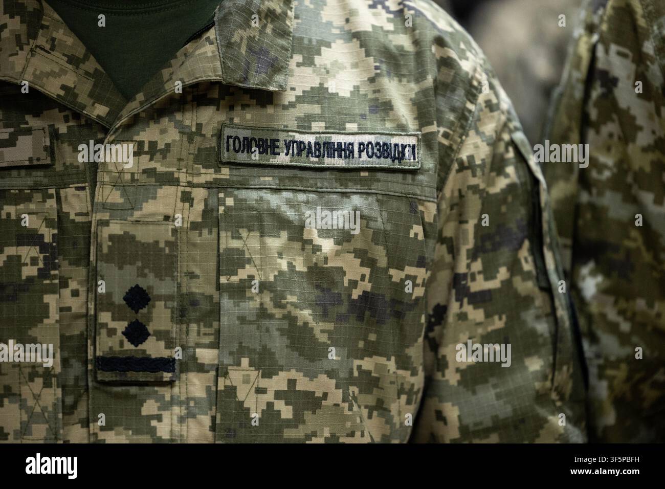 Identità militare ucraina moderna: un'uniforme mimetica digitale, il patch dell'intelligence della difesa e gli stemmi del grado di ufficiale displayed sul petto Foto Stock