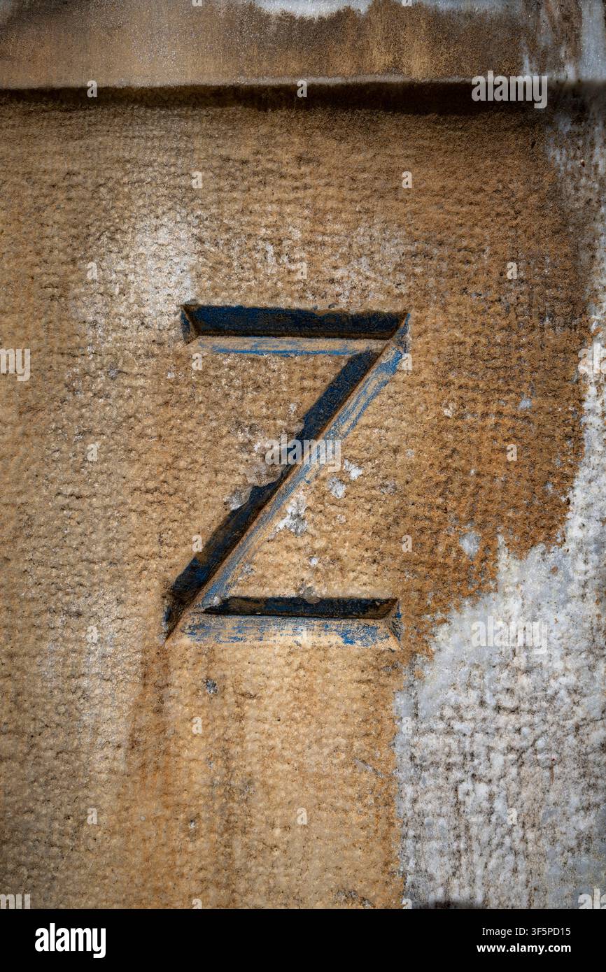 Lettera Z incisa in un muro di pietra con texture consumata Foto Stock