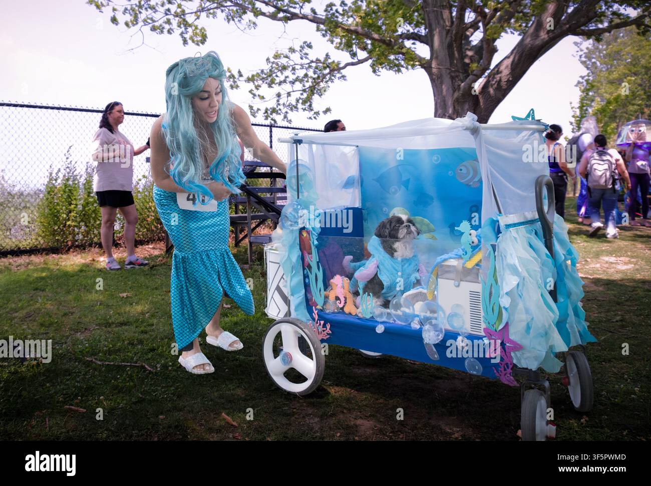 Una marciatrice attraente nella sfilata del Festival delle Sirene e il suo cane che hanno vinto il premio per il miglior costume per animali domestici. Nel parco Kingsland Point a Sleepy Hollow, NY. Foto Stock