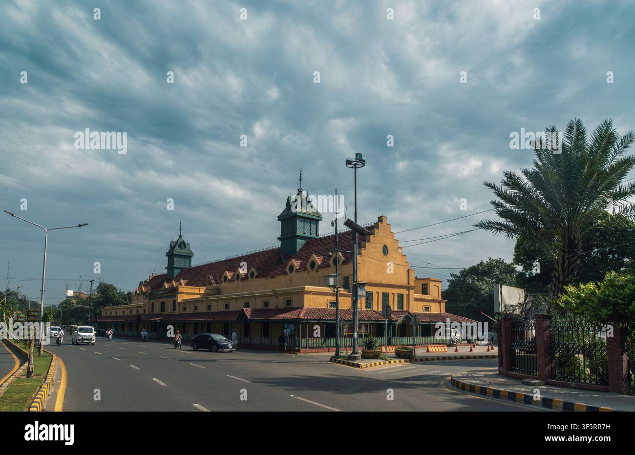 Vista dell'edificio storico di Old Tollinton Market con la sua caratteristica facciata gialla, le torrette del tetto verdi e le finestre ad arco, situato lungo una strada Foto Stock