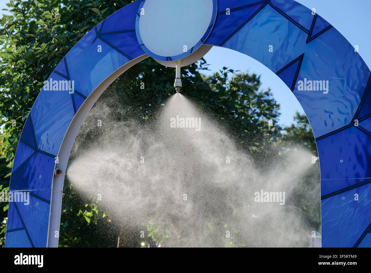 Arco di nebbia rinfrescante da esterno in una calda giornata estiva Foto Stock