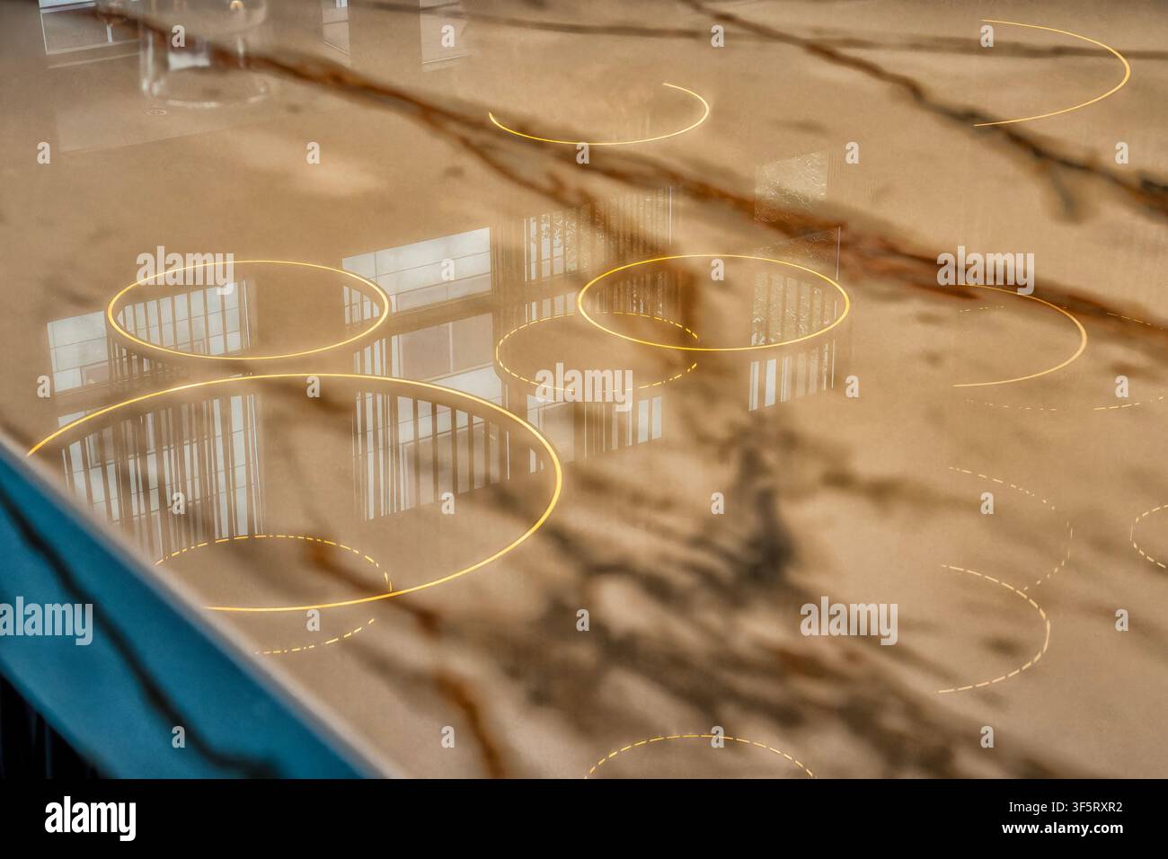 Un piano di lavoro lucido in quarzo o resina epossidica con elementi di illuminazione circolari integrati e una finitura simile al marmo Foto Stock