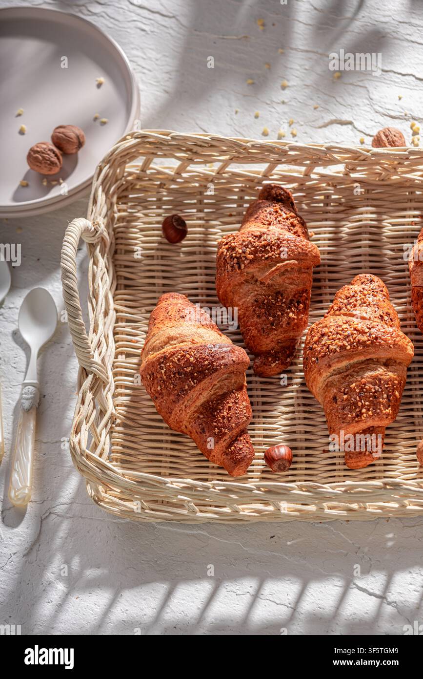 Croissant francesi alle noci dorati e caldi per una colazione dolce. Colazione con caffè e croissant. Foto Stock