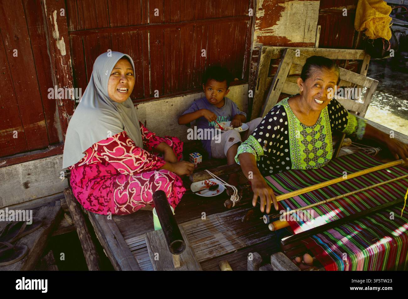 Isola di Flores, Koja Doi. Donne che tessono tessuti tradizionali Sikka sull'isola di Koja Doi al largo della costa di Maumere, Indonesia. Foto Stock