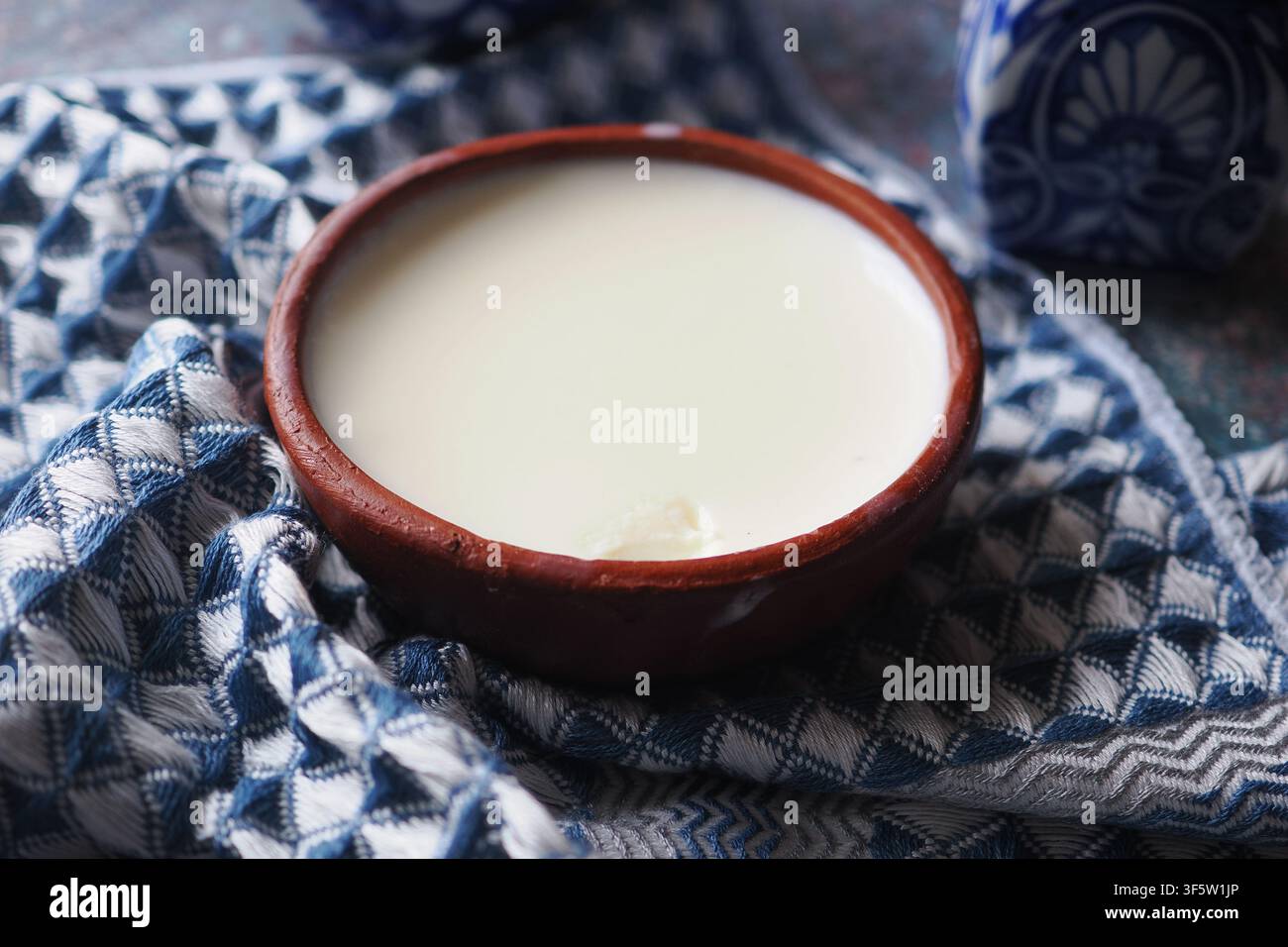 Ciotola di yogurt naturale su un panno blu e bianco Foto Stock