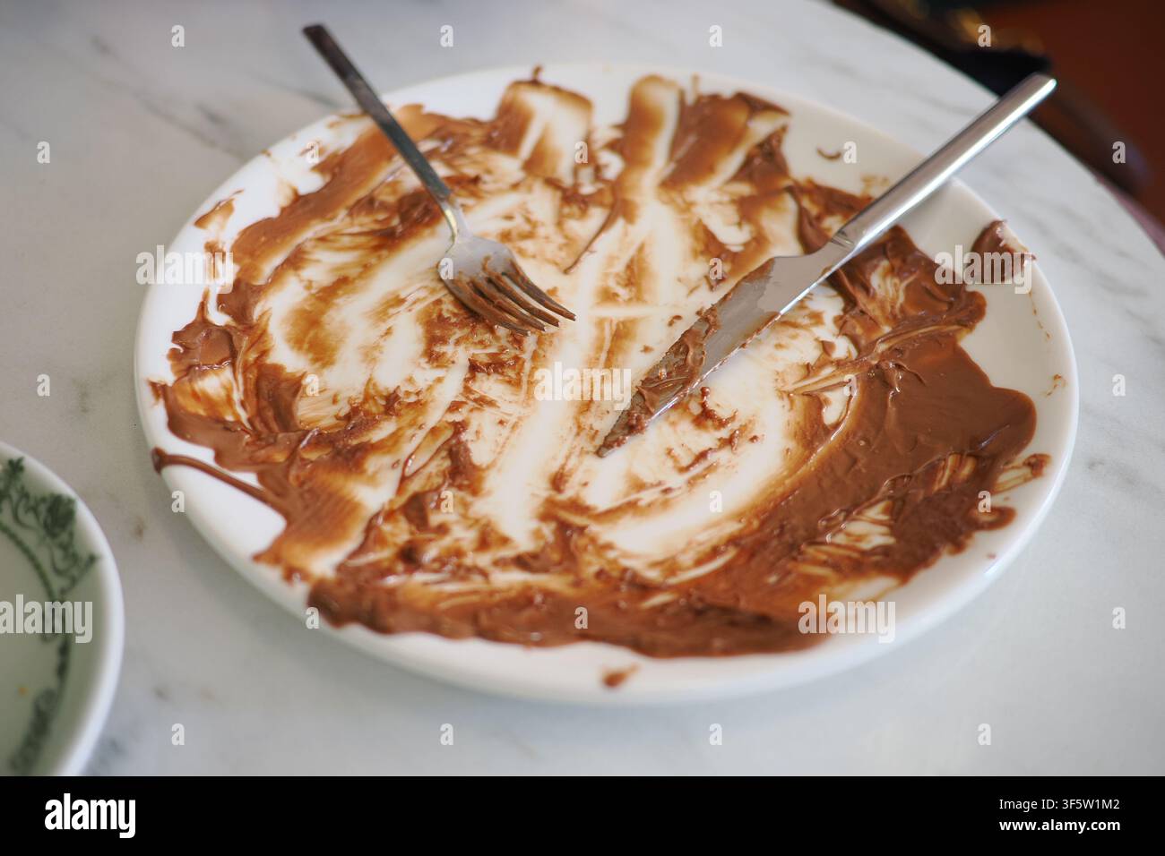 Le persone gustano il dessert e finiscono i loro piatti in un caffè Foto Stock